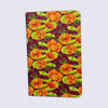 small notebook with rounded corners featuring a pattern of illustrated two headed snakes and orange flowers