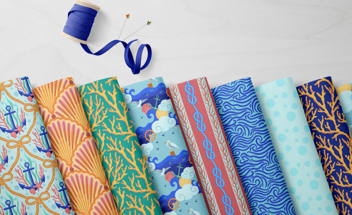 Collection of patterned fabric swatches on a light gray background with sewing tools.