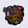 Sticker with 'Babes against bigotry' text and decorative elements on a light gray background