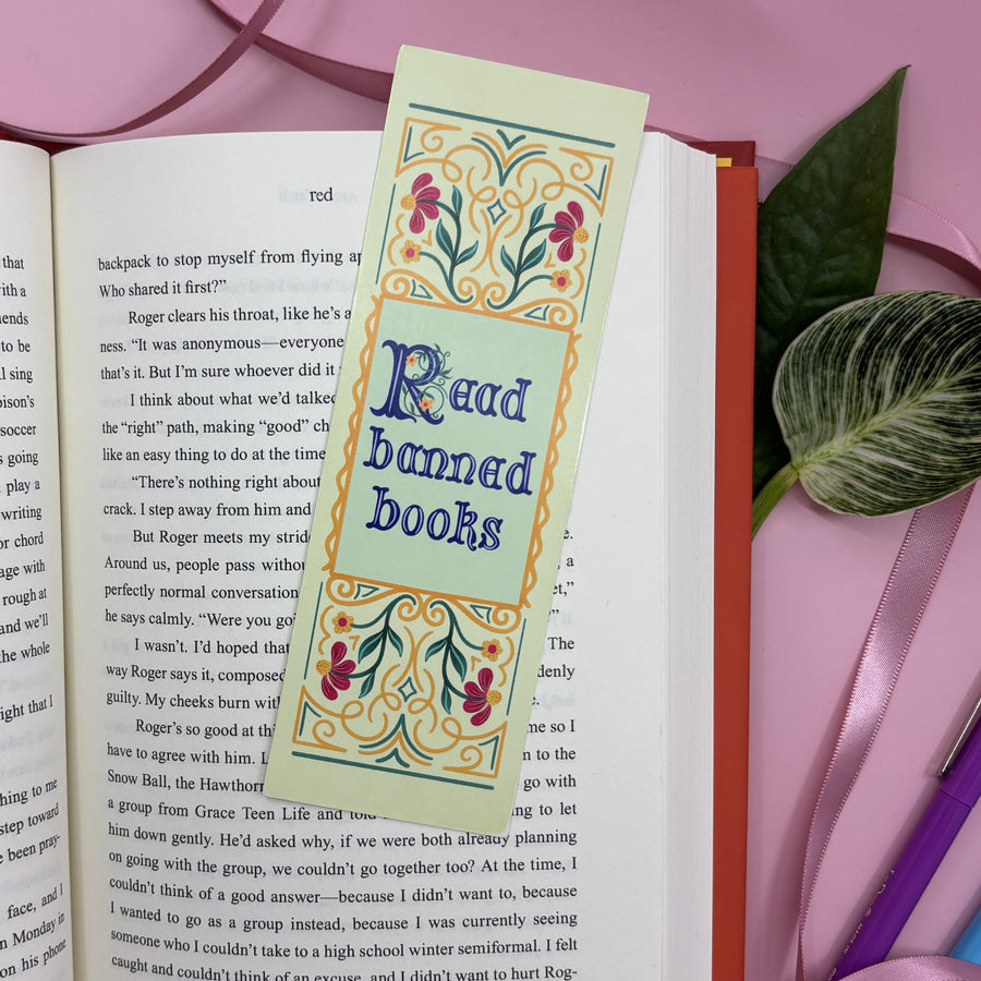 Bookmark with 'Read banned books' text on an open book with a pink background