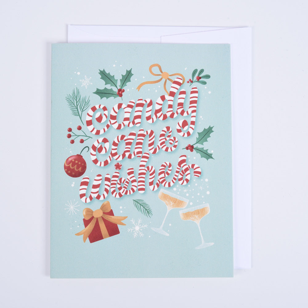 A folded greeting card with a candy cane design and 'candy cane wishes' text, paired with a bright white envelope.