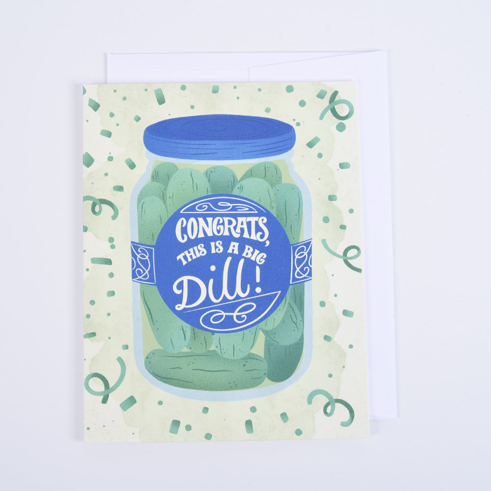 A folded greeting card with a colorful illustration of a pickle jar and the text 'CONGRATS this is a BIG DILL!' 