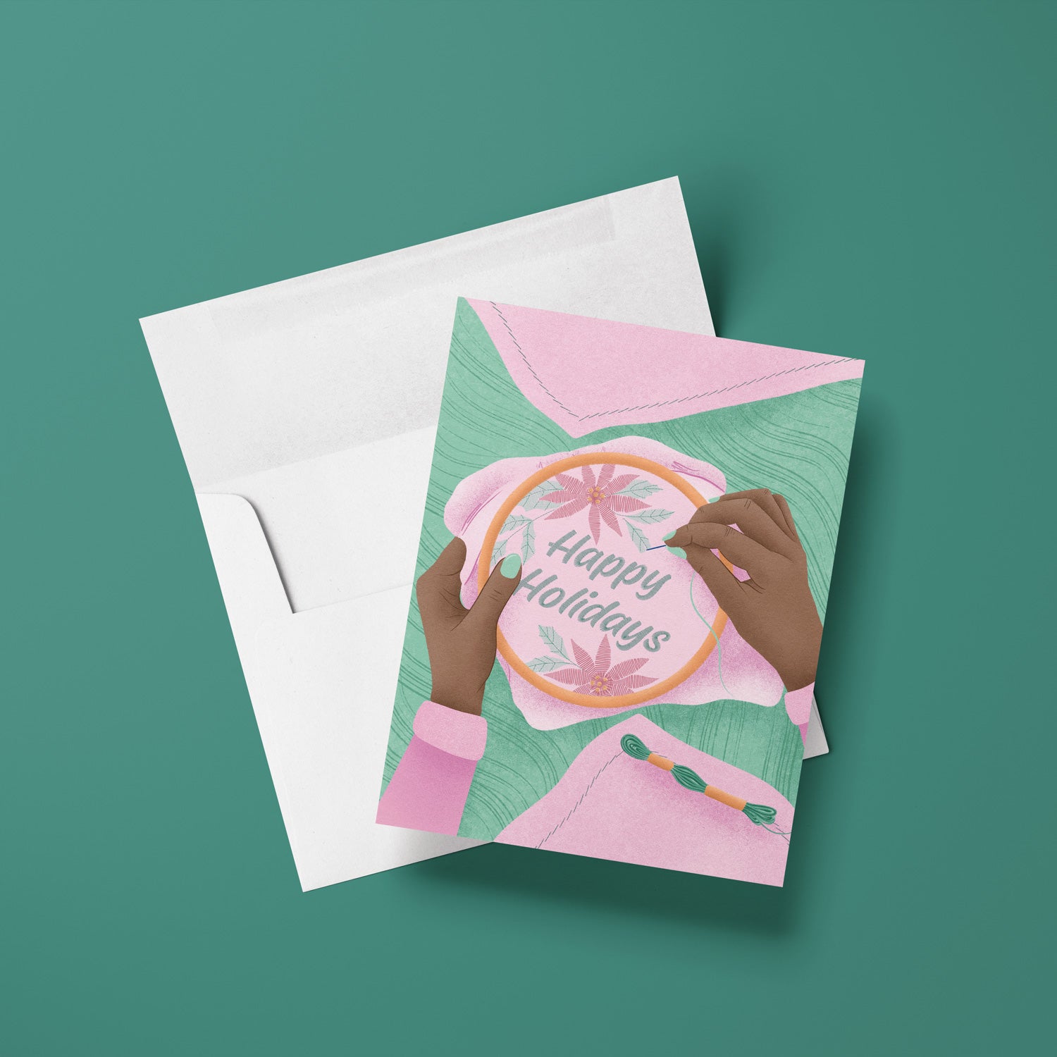 Greeting card with embroidered hoop and 'Happy Holidays' text on a green background