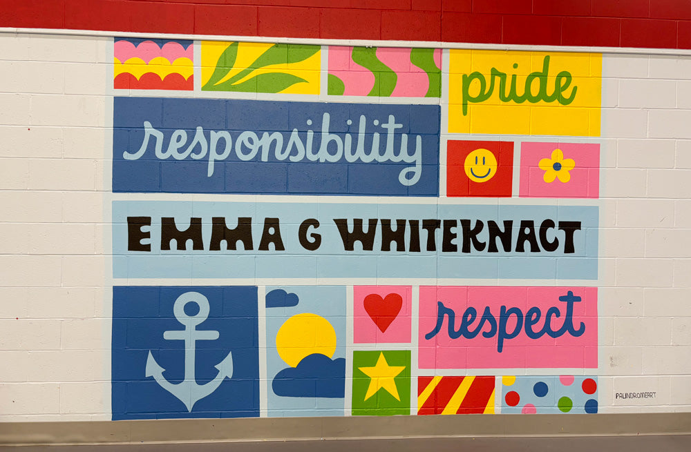 Colorful mural on a wall with text and symbols at an elementary school