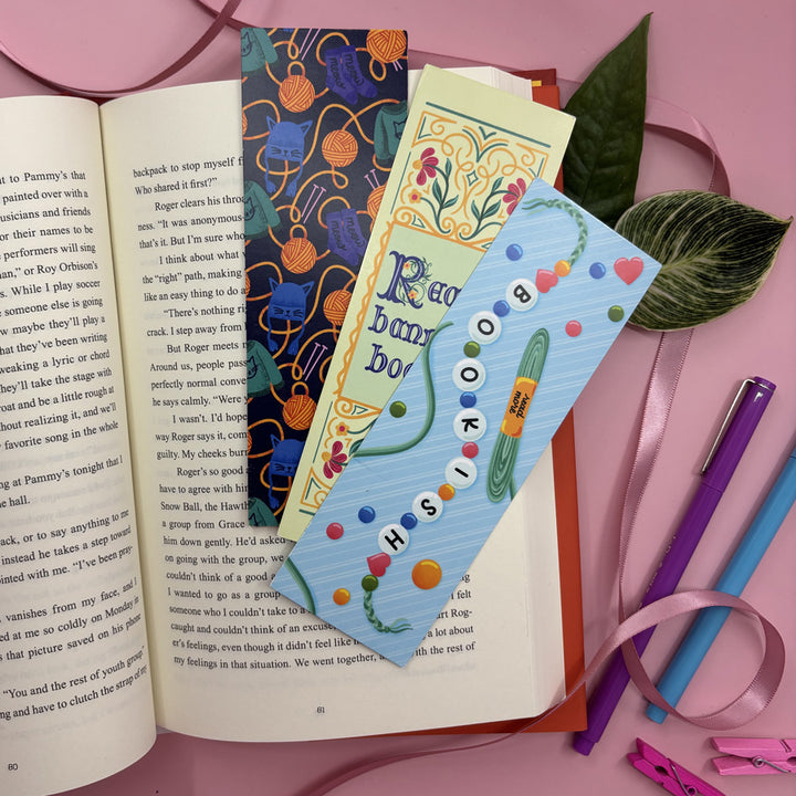 Colorful illustrated bookmarks on an open book with a pink background