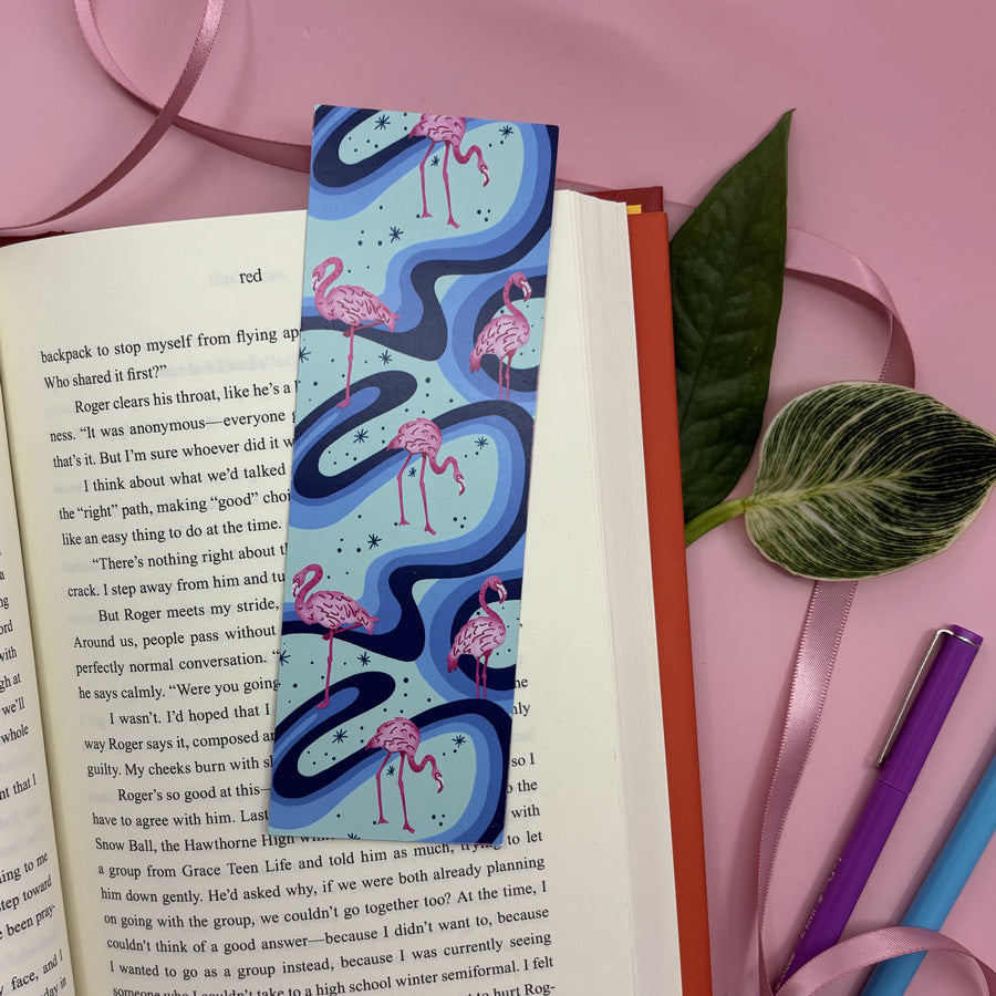 Flamingo-themed bookmark on an open book with a pink background