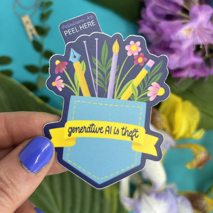 Sticker with 'generative AI is theft' text held by a hand against a colorful background