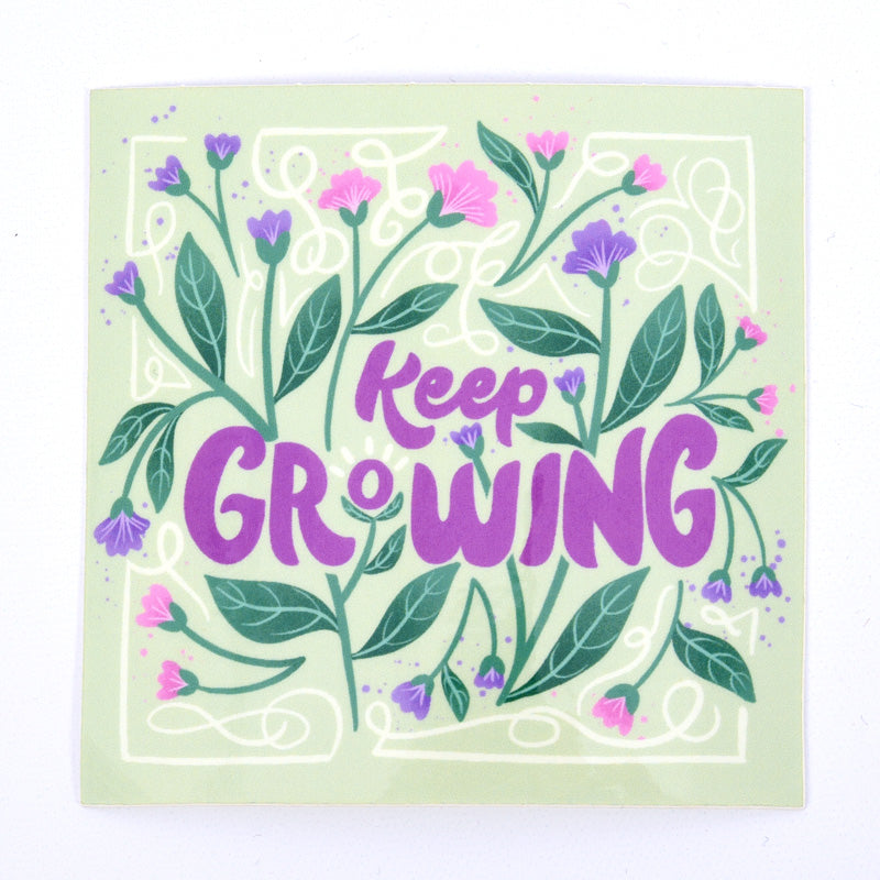 A sticker with a floral design and the text 'Keep Growing' in purple.