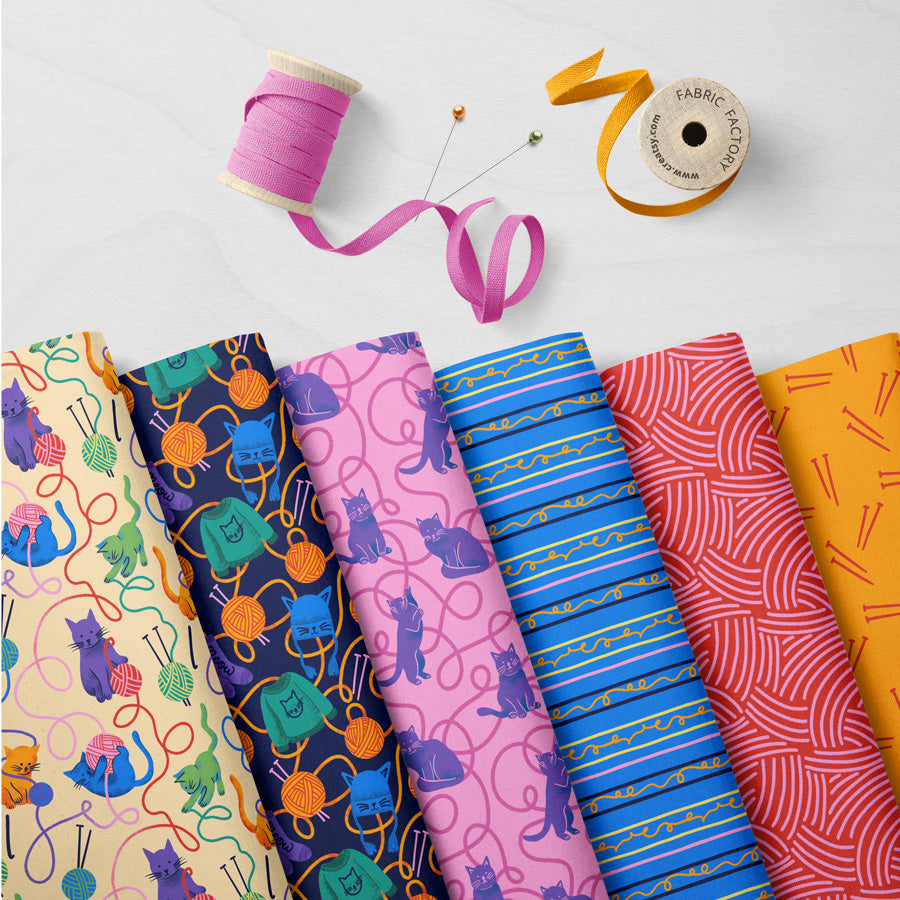 Collection of colorful fabric swatches with sewing tools on a white background