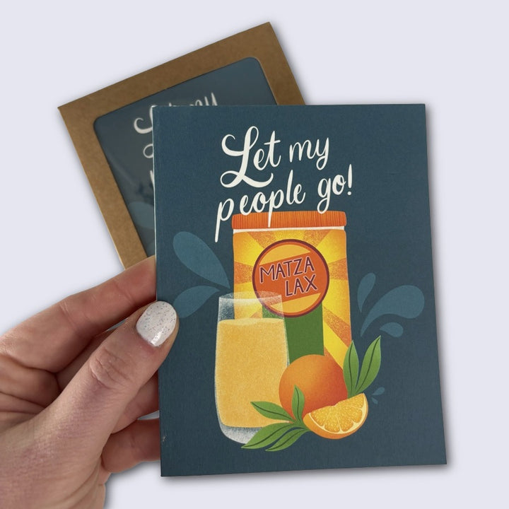 Card with 'Let my people go! Matza Lax' text and illustration held by a hand.