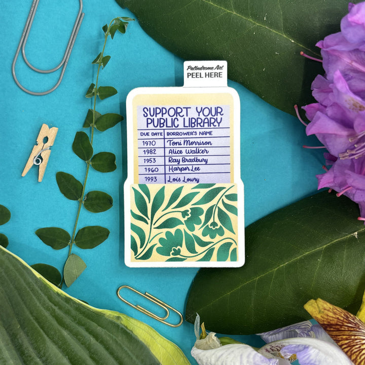 sticker with 'Support Your Public Library' message on a blue background with green leaves and flowers.