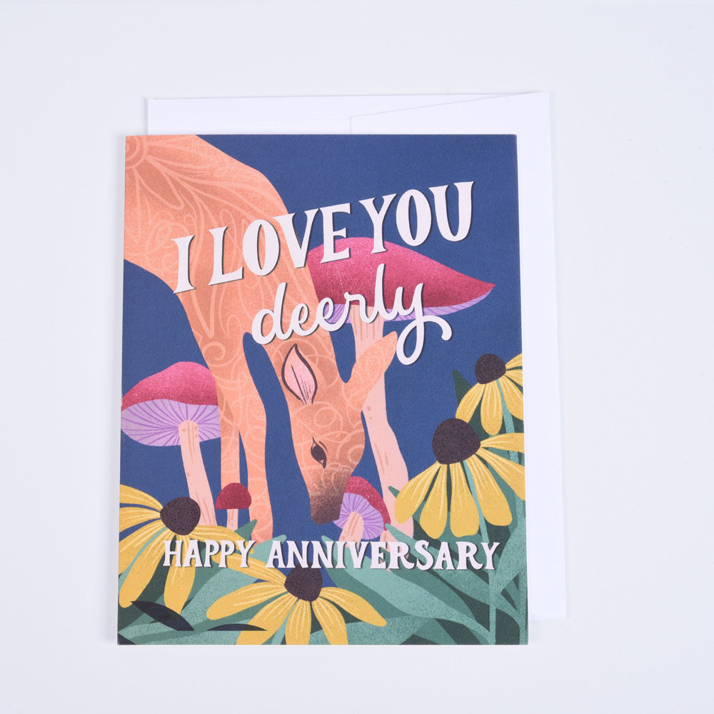 A folded greeting card with a colorful illustration of a deer and mushrooms, with the text 'I love you deerly' and 'Happy Anniversary'.