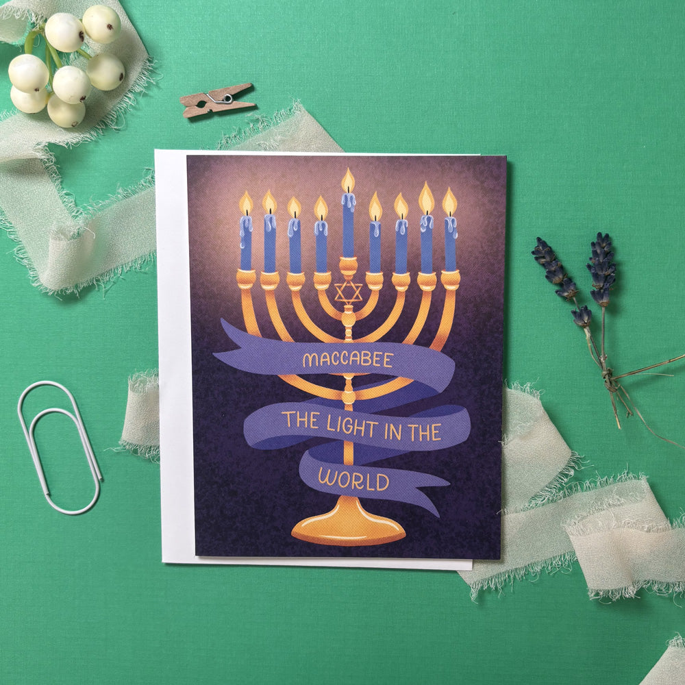 Card with Menorah illustration and banner that says "maccabee the light in the world"