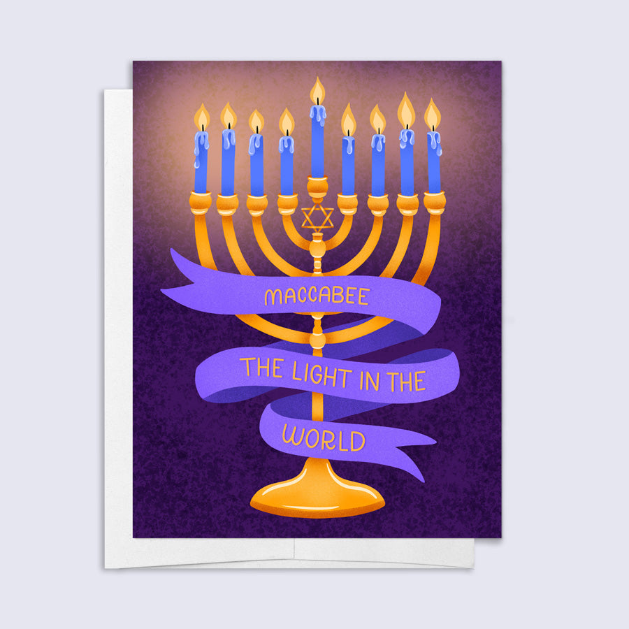 Card with Menorah design and text on a purple background that says "maccabee the light in the world"