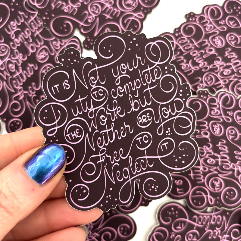 Decorative stickers with intricate text design held by a hand with blue nail polish. Sticker reads "it is not your duty to complete the work but neither are you free to neglect it"