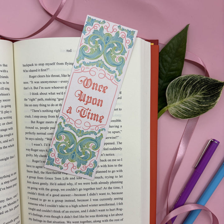 Decorative 'Once Upon a Time' bookmark on an open book with a pink background