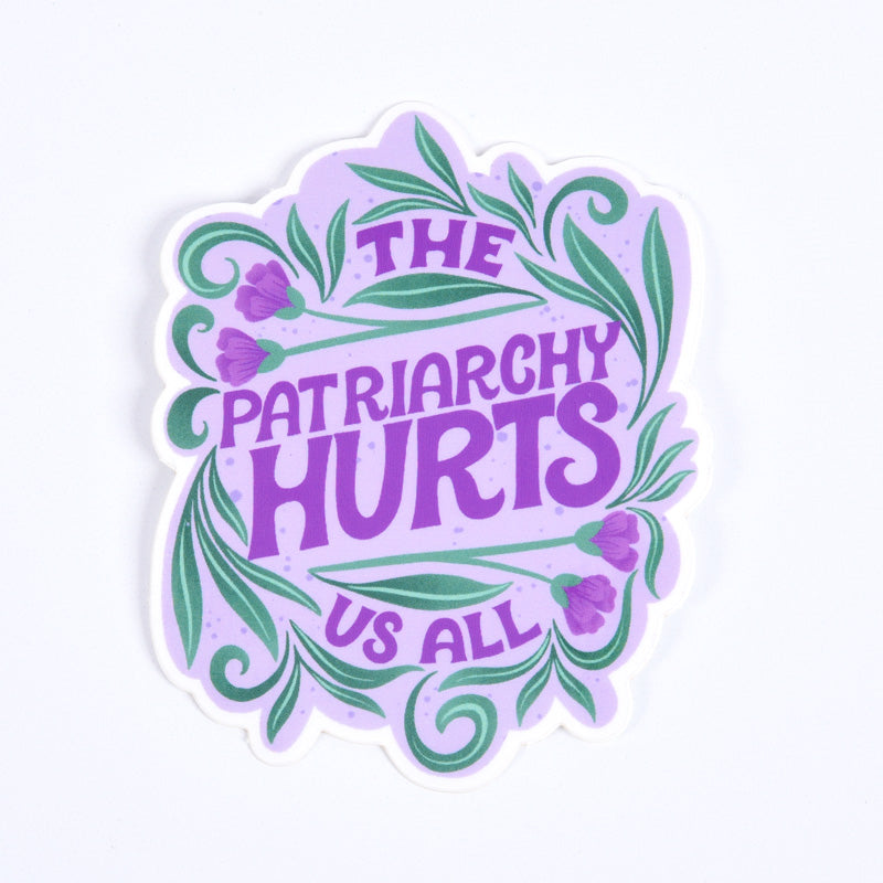 A sticker with a purple background and the text 'THE PATRIARCHY HURTS US ALL' along with floral designs.