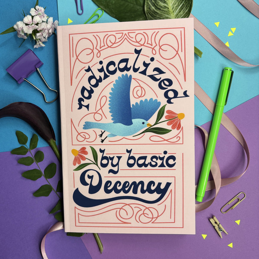 journal with lettering 'radicalized by basic decency' with decorative elements on a colorful background