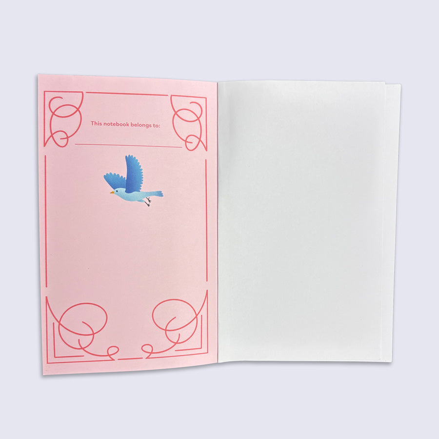 Open notebook with pink inner cover featuring a blue bird illustration on a light gray background