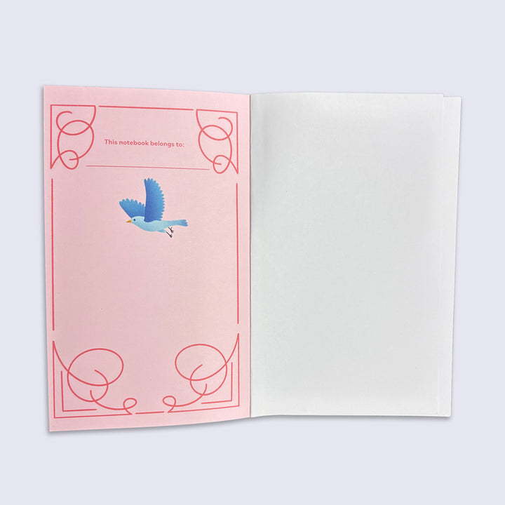 Open notebook with pink inner cover featuring a blue bird illustration on a light gray background