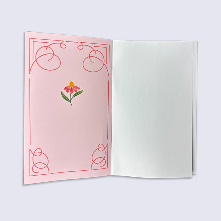 Open journal with a pink cover featuring a floral design on a white background