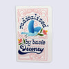 A small pink notebook with rounded corners featuring a colorful retro-style illustration of a blue bird and the text 'radicalized by basic decency' in dark blue script.