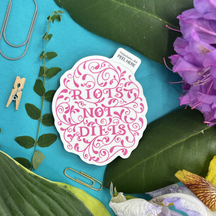 Sticker with 'Riots Not Diets' text on a blue background with leaves and flowers.