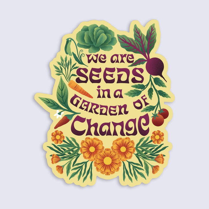 Sticker with 'we are seeds in a garden of change' text surrounded by vegetables and flowers on a light purple background.