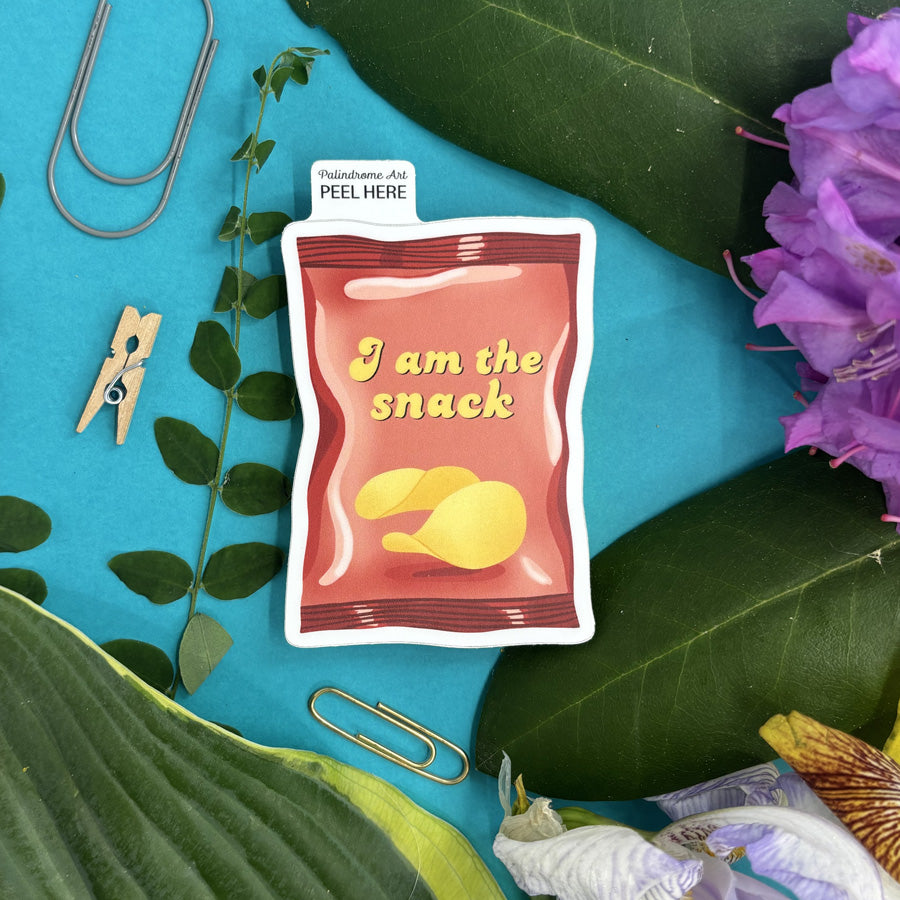 Sticker of a snack package with text 'I am the snack' on a blue background with green leaves and flowers.