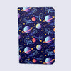 a small notebook with rounded corners featuring illustrations of whales with space helmets exploring space amid planets and stars