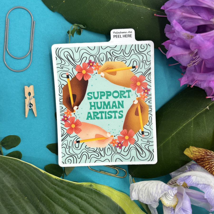 sticker with 'Support Human Artists' text on a blue background with flowers and leaves.