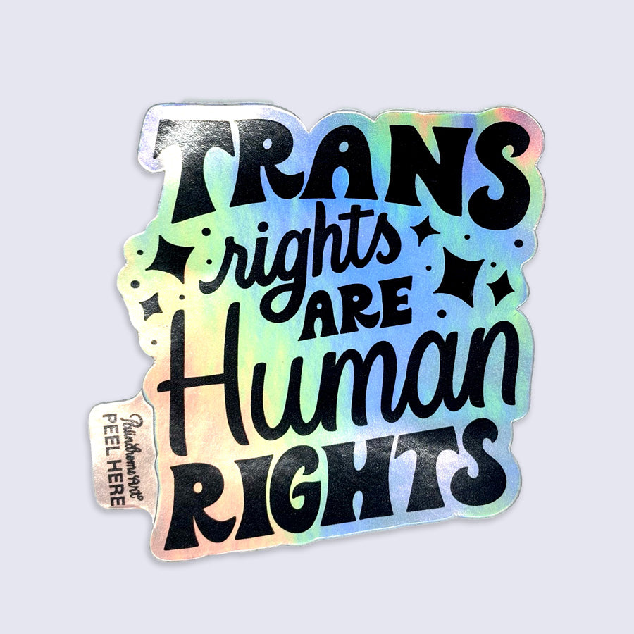 Holographic sticker with 'Trans rights are human rights' text on a light gray background