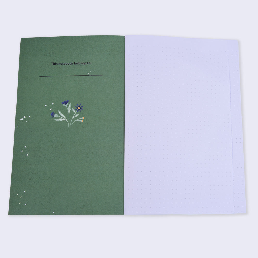 open notebook with dot grid pages, left cover page is green with a small flower illustration and text "this notebook belongs to"