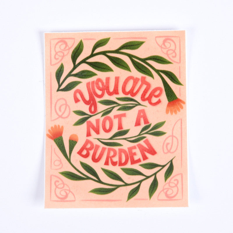 A sticker with a floral pattern and the text 'You are not a burden' in a red cursive font, on a pink background.