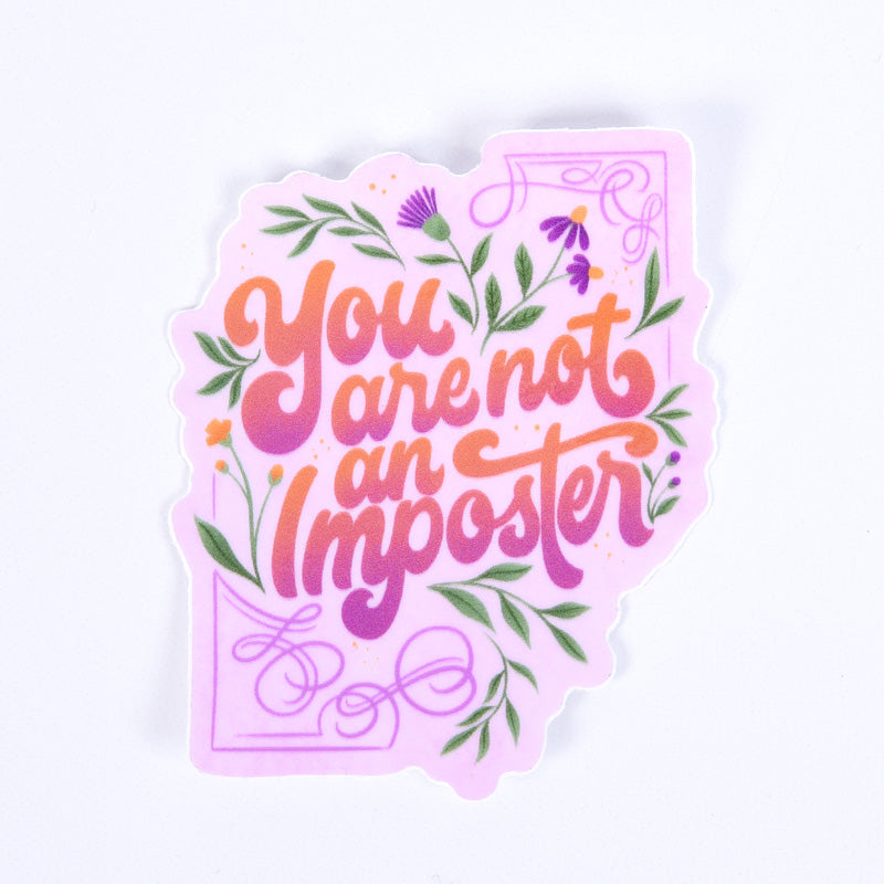 A sticker with a floral design and the lettering 'you are not an imposter' 